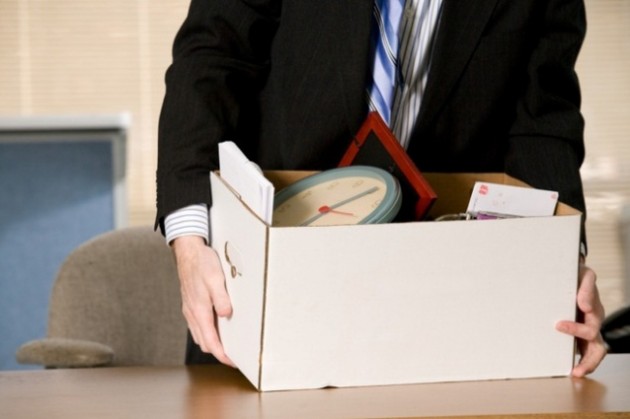 Businessman at desk with box of his belongings