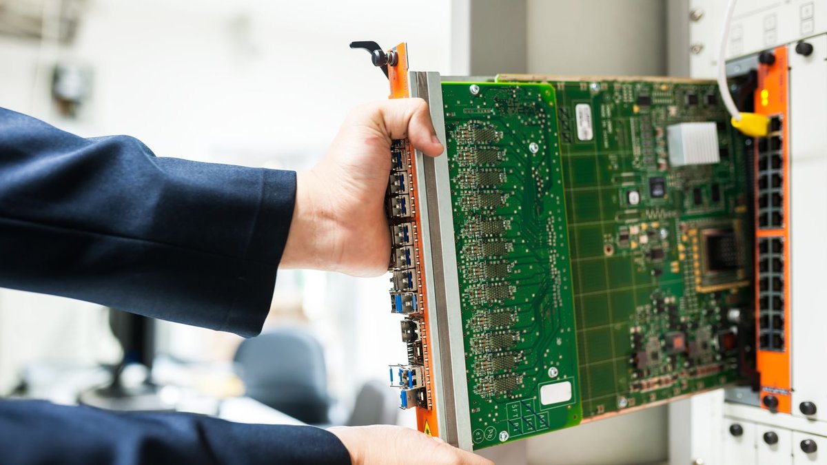 Técnico instalando una tarjeta en un rack de un centro de datos